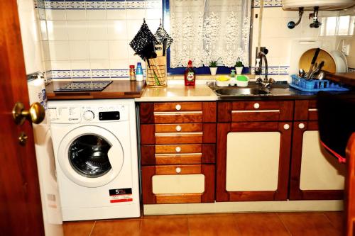 a kitchen with a washing machine and a sink at AlgarveInn in Altura