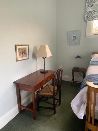 einen Schreibtisch mit einer Lampe und einem Stuhl neben einem Bett in der Unterkunft Hawkes Bay Villa-Beechwood in Hastings