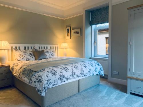 Un dormitorio con una cama grande y una ventana en Cliffside en Lossiemouth