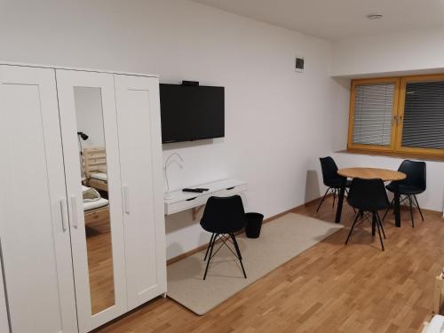 a room with a table and chairs and a tv at PUBYLAND ROOMS & APARTMENTS in Rogatec