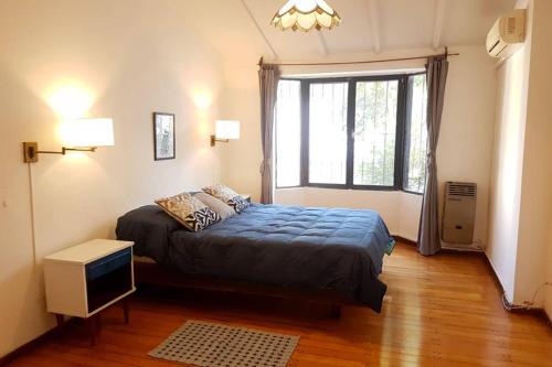 Un dormitorio con una cama grande y una ventana en Big beautiful house with garden in 5ta Sección neighbourhood en Mendoza