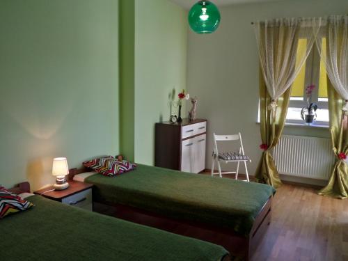 a bedroom with two beds and a chair and a window at Apartamenty Silver Premium in Warsaw
