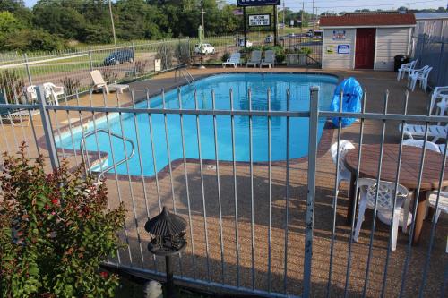 una piscina con una mesa y una valla en Savannah Lodge, en Savannah