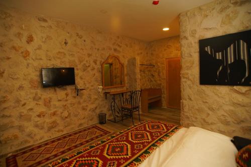 a living room with a television and a rug at Infinity Lodge in Wadi Musa