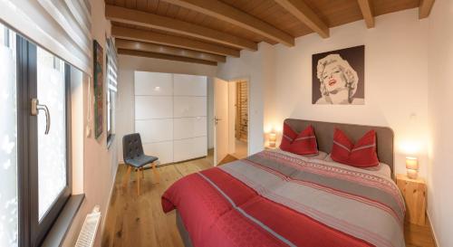 - une chambre avec un grand lit et des oreillers rouges dans l'établissement Ferienhaus Weinhäusel, à Neustadt an der Weinstraße