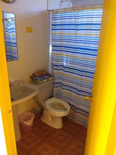 a bathroom with a toilet and a sink and a shower curtain at Resimed in Antofagasta