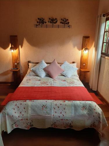 Un dormitorio con una cama grande con almohadas. en Chale Raio De Luz, en Visconde De Maua