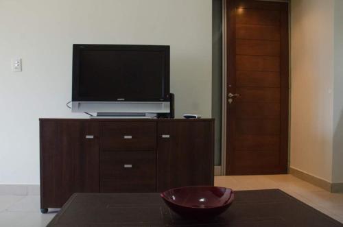 a living room with a television on a cabinet with a bowl at Soles de Salta dpto, cochera, balcón a 600m de plaza principal in Salta
