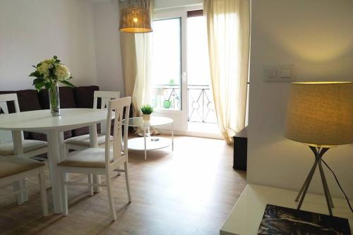 ein Wohnzimmer mit einem Tisch, Stühlen und einem Fenster in der Unterkunft Apartamento Teresa in Pontevedra