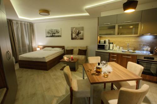um quarto com uma cama, uma mesa e uma cozinha em Apartman BIG Milmari S19 em Kopaonik