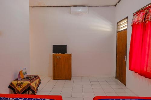a room with a room with a tv on a wall at OYO 1847 Hotel Maya in Blitar