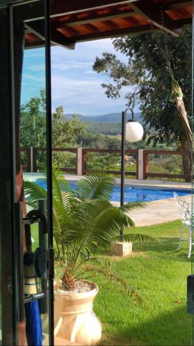 a porch with a plant in a pot next to a pool at Pousada Yvanna in Pirenópolis