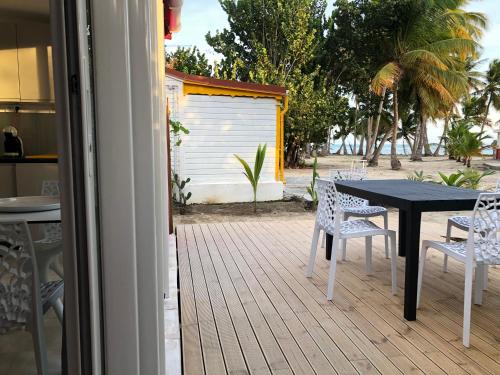 a patio with a table and chairs on a deck at Be On The Beach in Sainte-Anne