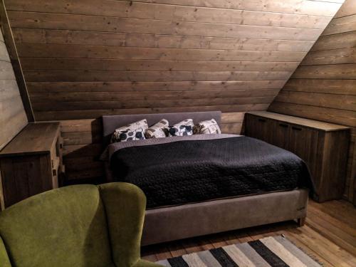 a bedroom with a bed and a chair in a attic at Chata Čerenka in Bytca