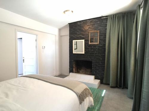 a bedroom with a brick fireplace and a bed at L'Hotel Particulier Griffintown in Montréal