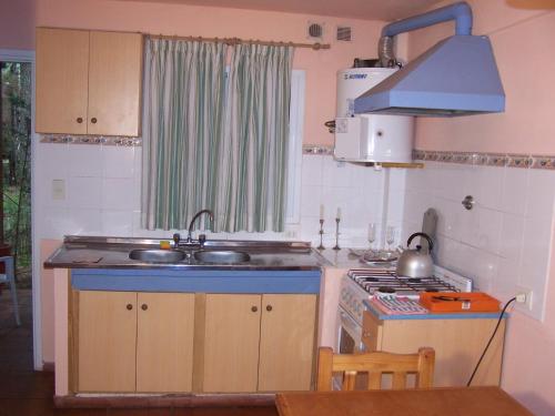 a kitchen with a sink and a stove at Cabañas MARE PARADISO in Costa del Este