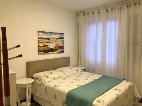 Habitación pequeña con cama y ventana en Apartamento ao som do mar, en Balneário Camboriú