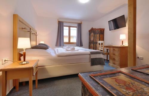um quarto com uma cama grande e uma televisão em Hotel Hvezda em Pec pod Sněžkou