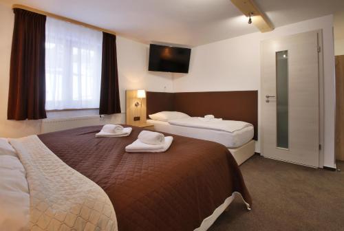 a hotel room with two beds with towels on them at Hotel Hvezda in Pec pod Sněžkou