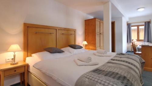 a bedroom with a large white bed with two pillows at Hotel Hvezda in Pec pod Sněžkou