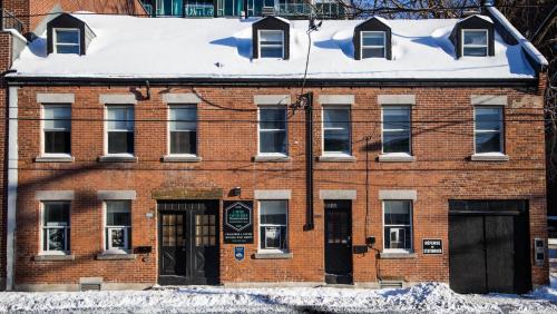 a red brick building with snow on the roof at L'Hotel Particulier Griffintown in Montréal