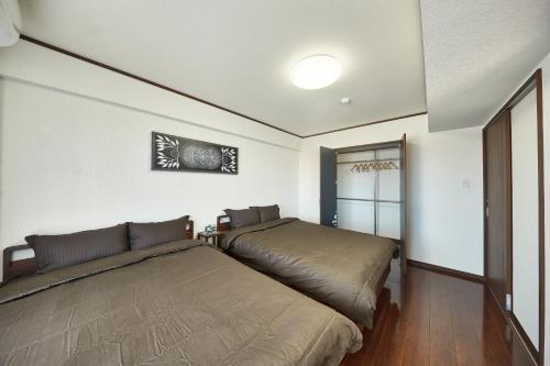 a bedroom with two beds in a room at FreedomHillsフリーダムヒルズA棟 in Tomigusuku