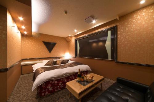 a hotel room with a bed and a flat screen tv at HOTEL le ROSEY in Kitakyushu