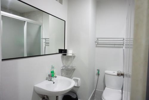 uma casa de banho branca com um lavatório e um espelho em Comfy condo unit 5mins from Mactan Airport+Netflix em Mactan
