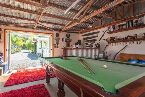 a room with a pool table with cuesticks on it at Peacock Lodge in Ngunguru in Ngunguru