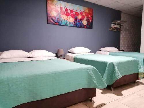 a room with two beds and a painting on the wall at Kayva in Trujillo