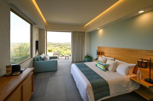 a hotel room with a bed and a large window at Hotel Basalto in Punta Mita