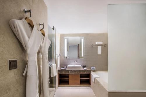 a bathroom with a sink and a bath tub and a sink at Ascott Raffles City Chengdu in Chengdu