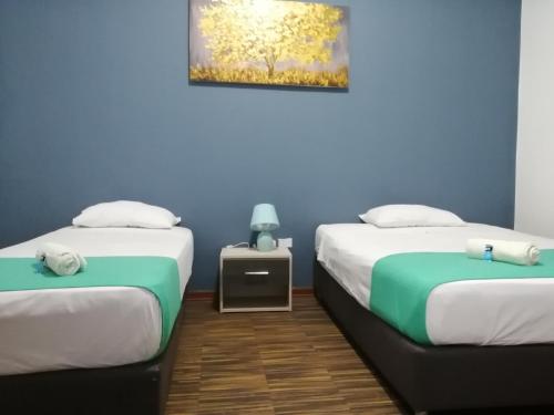 two beds in a room with blue walls at Kayva in Trujillo