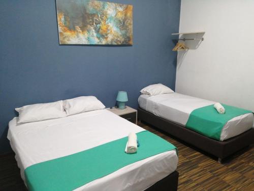 a room with two beds and a painting on the wall at Kayva in Trujillo