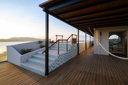 a house on the beach with a deck at Hotel Basalto in Punta Mita