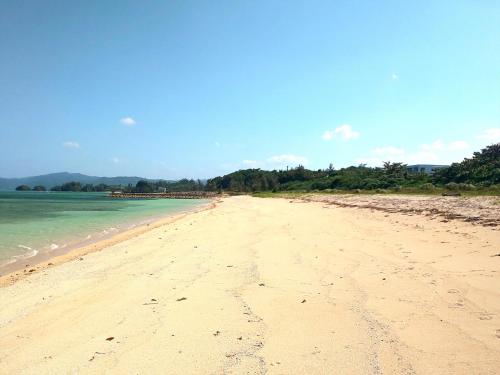 a view of a sandy beach with the ocean at Uminchuno Yado in Nago