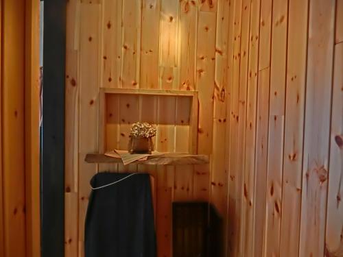 a room with a wooden wall with a shelf and a chair at Hakuba Kaze no Ko in Hakuba