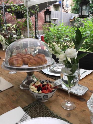 a table with a plate of pastries and a bowl of fruit at L'Hotel Particulier Griffintown in Montréal