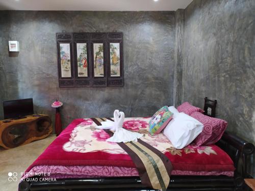 a bedroom with a bed with pink sheets and a window at Angels Chambres d'hotes in Rong Sak