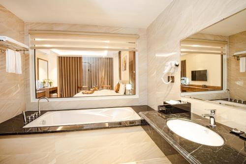 a bathroom with a tub and a large mirror at Manh Quan Luxury Hotel in Yen
