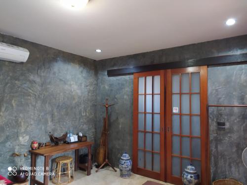 a room with a wooden door and a table at Angels Chambres d'hotes in Rong Sak