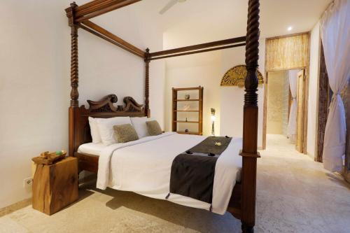 a bedroom with a large bed with a wooden frame at The Bejalin Eco Retreat in Plaga
