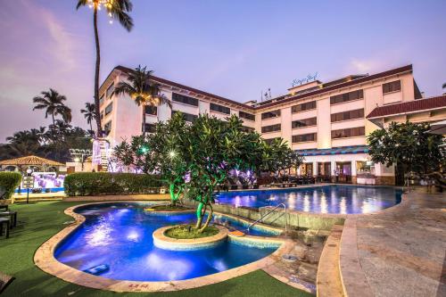 een hotel met een zwembad voor een gebouw bij Sun-n-Sand Mumbai Juhu Beach in Mumbai