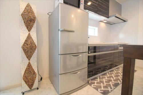a stainless steel refrigerator in a kitchen at Casa de nicki 恩納村 in Onna