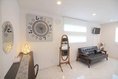 a living room with a black leather couch and a table at Casa de nicki 恩納村 in Onna