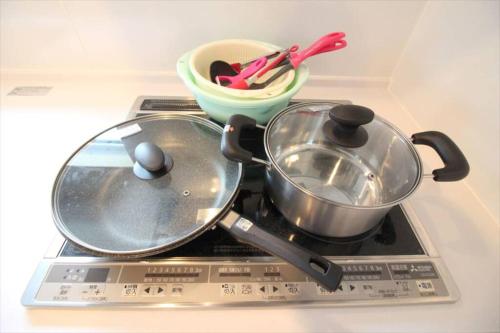 a stove with two pans and a bowl on it at Casa de nicki 恩納村 in Onna
