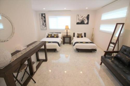 a large room with two beds and a couch at Casa de nicki 恩納村 in Onna