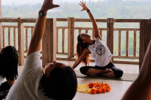 a group of people doing yoga on a balcony at The Bejalin Eco Retreat in Plaga