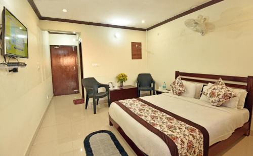 a hotel room with a bed and a desk and chairs at Green Roof Hotel in Nainital