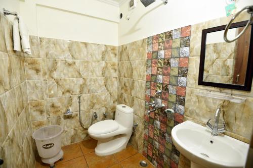 a bathroom with a toilet and a sink at Green Roof Hotel in Nainital